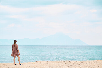 Greece, Rear view of woman looking at mount Athos across sea