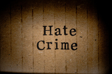Gestempelter Text auf zerknittertem Pappkarton. Hate Crime.