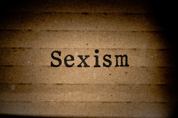 Gestempelter Text auf zerknittertem Pappkarton. Sexism.