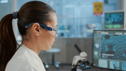 Biology specialist working with computer to examine dna animation in laboratory. Microbiologist...