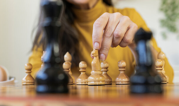 Mature woman playing chess at home