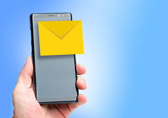 E-mail concept. Emails in a smartphone. The envelope icon on the smartphone screen. A person is holding a phone with an email program in his hand. Space for text on a blue background. 3d image