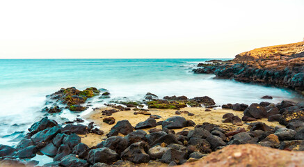 Fototapeta na wymiar beautiful sunset on the beach of the island of gran canaria with beautiful lights silky water and wonderful sunset scenery of the canary islands in paradisiacal beaches