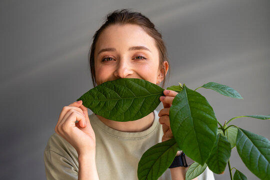 Woman Covering Mouth With Leaf At Home