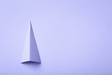 color of year 2022 - Very Peri. minimal lilac background with paper shape. purple christmas tree with copy space.