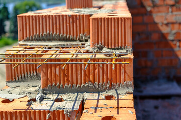 Brick reinforcement. Close up of industrial bricklayer installing bricks on construction site.