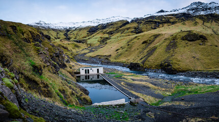 Panorama photo on Seljavallalaug, a beautiful, naturally heated swimming pool and hot spring in...