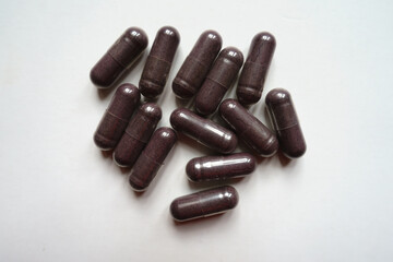 Heap of dark purple capsules of bilberry extract dietary supplement