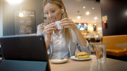 young female businesswoman working with her tablet in lunch pose