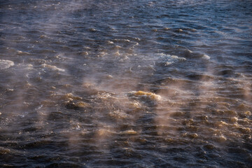 River waves on a sunny, foggy winter morning