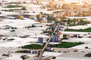 Aerial view of many greenhouses stretching across the resort and agricultural city of Demre in Turkey. Farming and business production of cucumbers, tomatoes and other vegetables