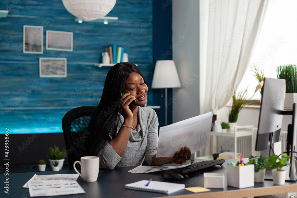 Poster businesswoman talking on phone call and looking at papers with data charts at desk. employee working