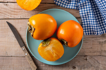 Fresh persimmon fruit on wooden table	