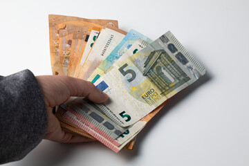 Hand holding a pile of euro cash banknotes 