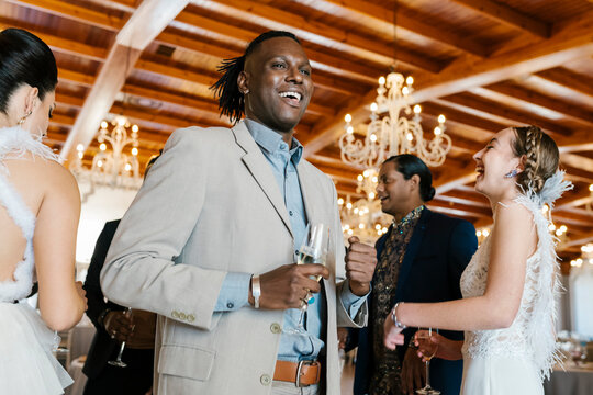 Happy male and female friends drinking champagne and enjoying at banquet
