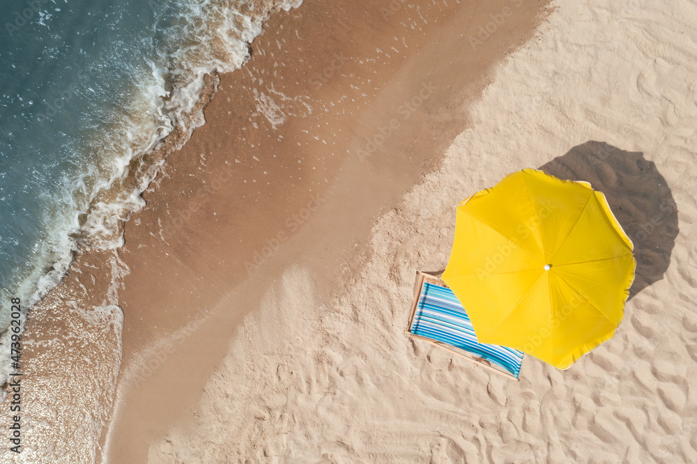 Sticker Yellow beach umbrella and sunbed on sandy coast near sea, aerial view. Space for text