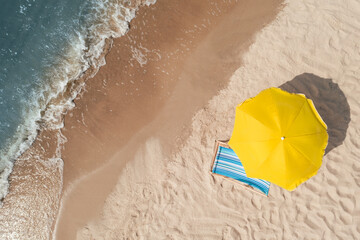 Yellow beach umbrella and sunbed on sandy coast near sea, aerial view. Space for text - obrazy, fototapety, plakaty