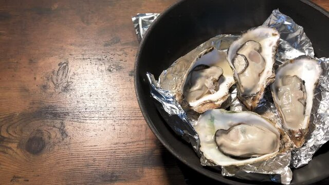 フライパンで焼いた、海から獲ってきた新鮮な殻付きのカキ　