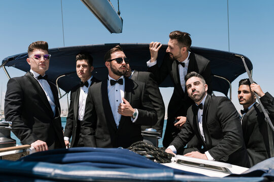 Elegant men looking away on yacht during summer