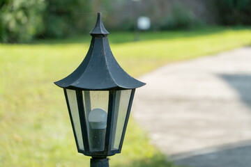 Decorative small garden lamp, Lanterns on a flower bed and in a green garden. Garden design. A small lantern gives coziness and comfort in the yard of the house.