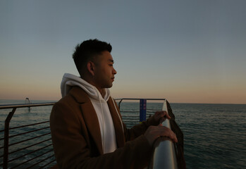 Silhouette of young asian man standing against nature landscape in deep thought