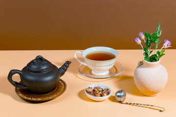 Tea in a cup in a composition with pastries and dessert, on a bright colored background.
