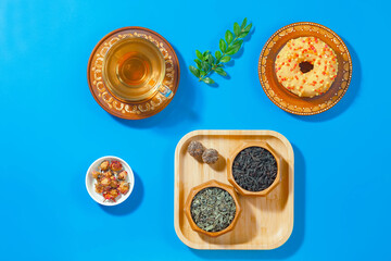 Tea in a cup in a composition with pastries and dessert, on a bright colored background.
