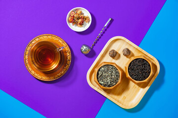 Tea in a cup in a composition with pastries and dessert, on a bright colored background.