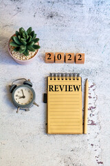 Review word on notebook with clock ,cactus and 2022 wooden cubes . 
Review and assessment concept