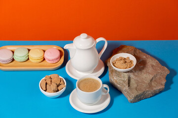 Coffee in a cup in a composition with dessert, on a bright, colorful background.