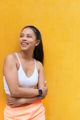 Portrait of a young sportswoman on a yellow wall