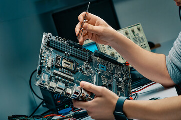 Technician in the service center testing electric circuit board