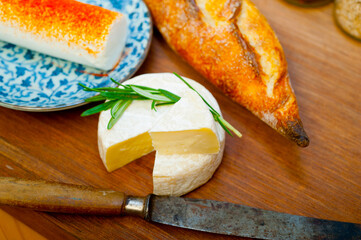 French cheese and fresh  baguette on a wood cutter
