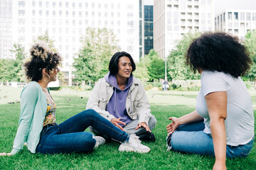 Young man talking to multi ethnic female friends at park