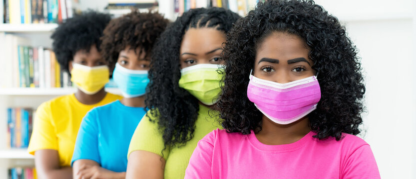 Group of pretty african american female young adults with colorful face masks