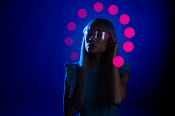 Young woman wearing smart glasses over blue background