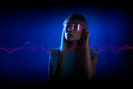 Young woman wearing futuristic glasses against blue background