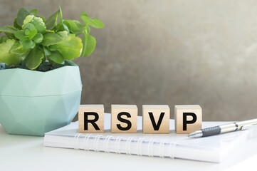 rsvp acronym request for a response from the invited person on wooden cubes on the office table.