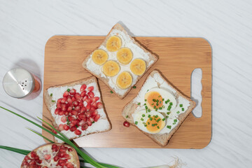 Bread has cream cheese and pomegranate boiled egg banana on white background.