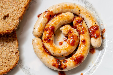Top view of fried sausages with sauce on a plate