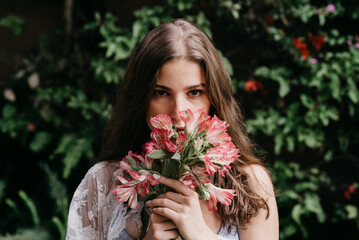 Young woman smelling fresh flowers