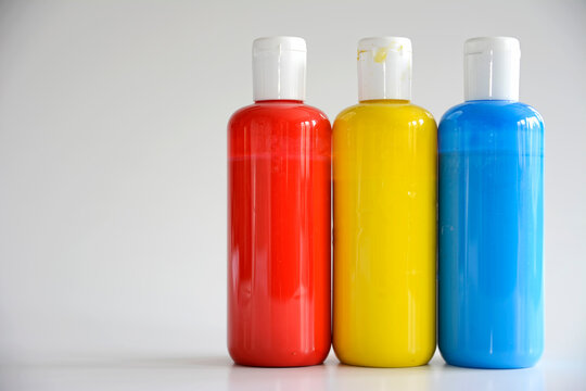 Red, Yellow, Blue bottles on gray background
