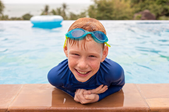 Close-up portrait of smiling boy playing in swimming pool, Thailand, Asia