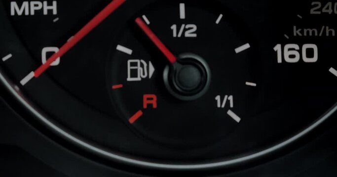 Closeup shot of a cars fuel gauge dropping to zero