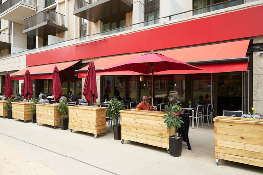 Couple sitting under parasol at sidewalk cafe