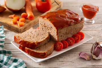 Traditional American meatloaf with ketchup on rustic wooden table