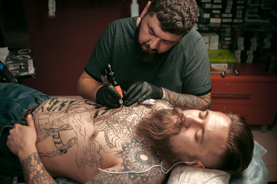 Tattoo master makes tattoo pictures in his salon