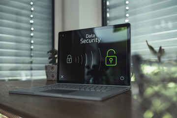 Laptop with data security icons on table at home