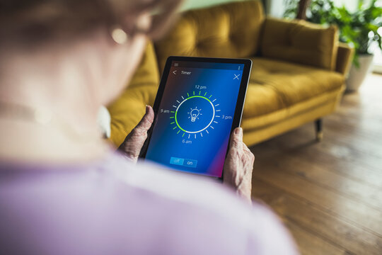 Woman checking timer on digital tablet at home