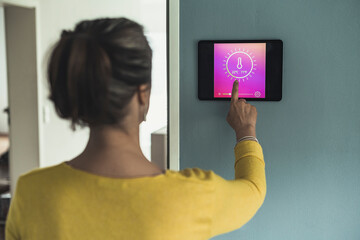 Woman using home automation device on wall